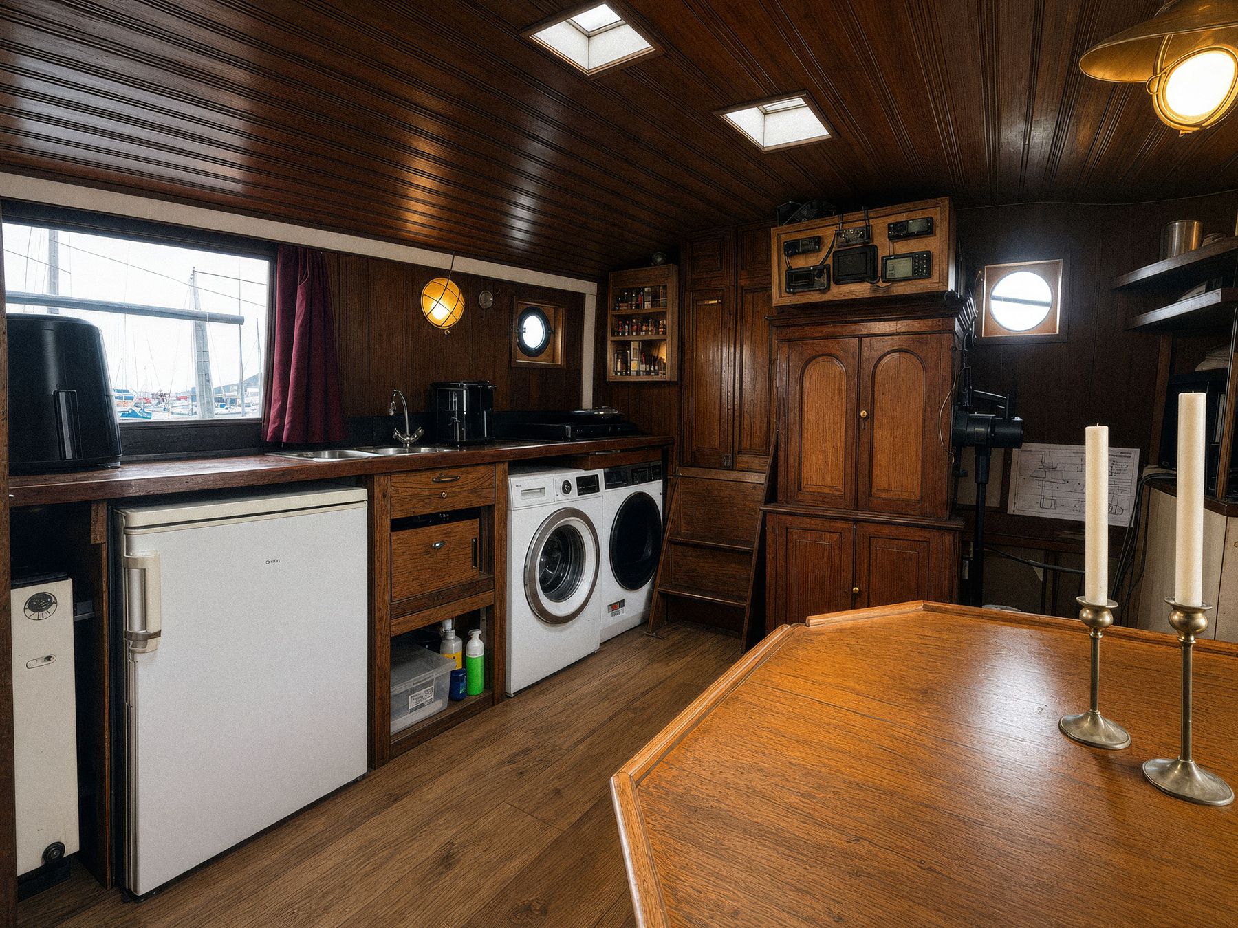 The skipper's galley with fridge, washing machine and dryer, portholes and a window onto the marina