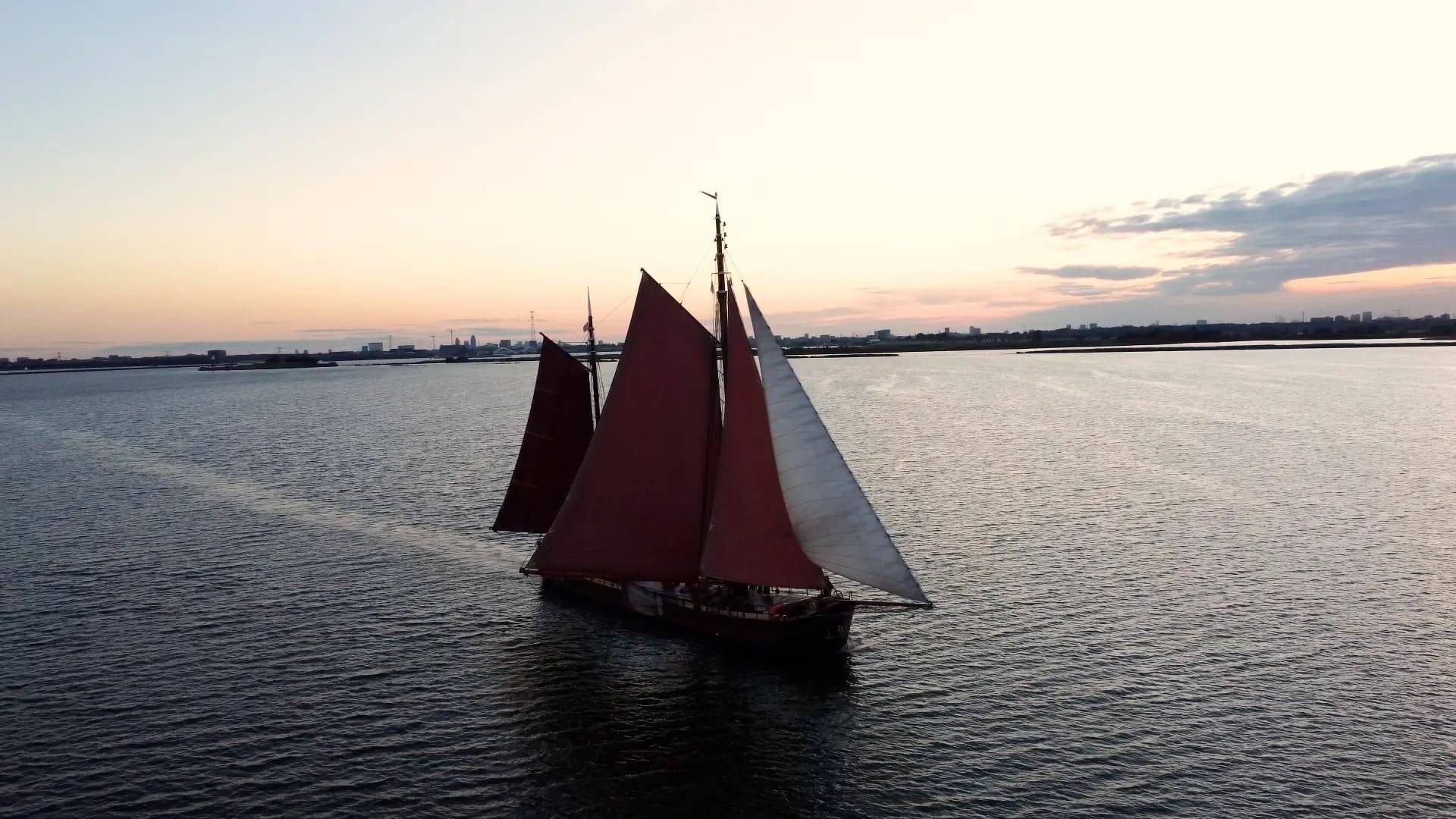 De Chateauroux under full sail at sunset, her brown sails catching the last light on the water near Amsterdam