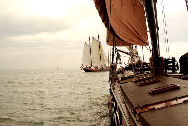 Another traditional sailing ship close by at dusk, seen past the rigging
