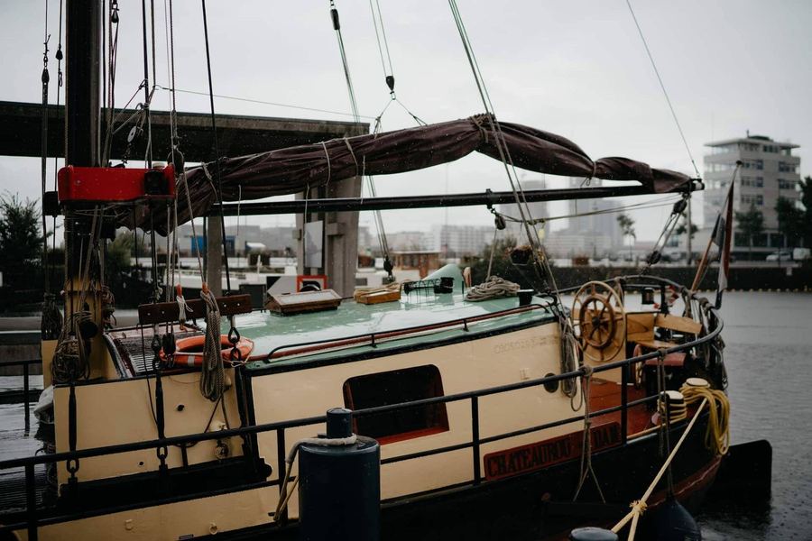 The stern and skipper's deckhouse of De Chateauroux moored at the wharf, Amsterdam's rooftops behind